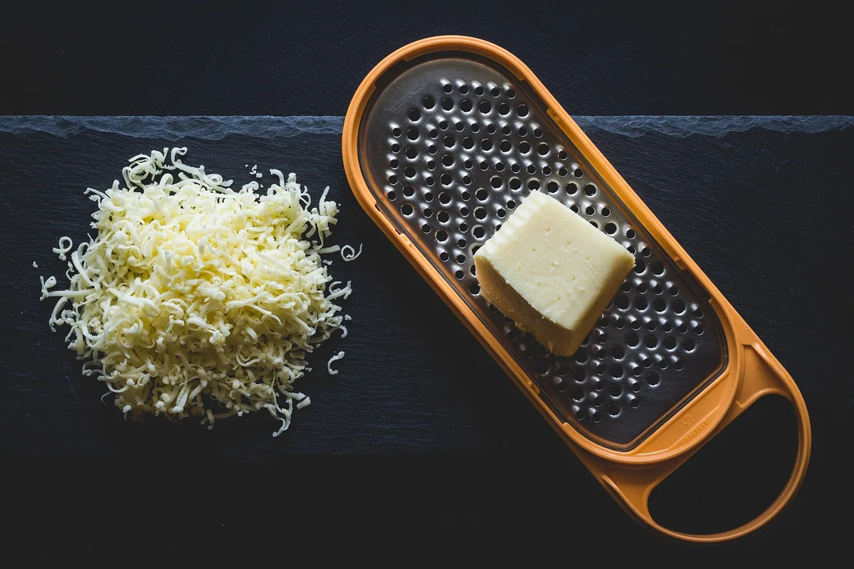 Personne mesurant une portion de fromage sur une balance de cuisine