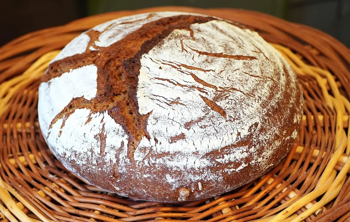 Pain au levain avec croûte foncée et mie irrégulière posé sur un comptoir